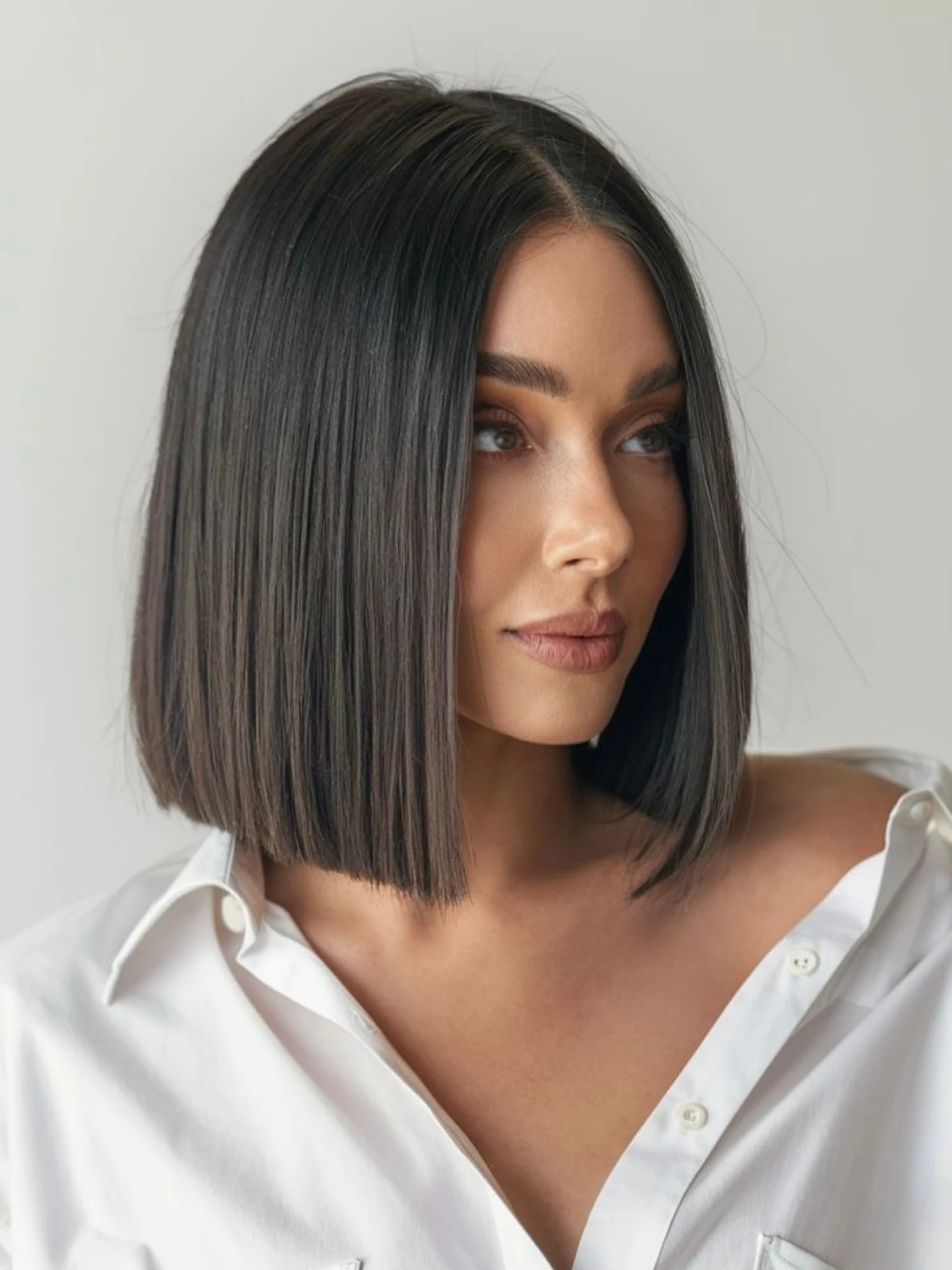 Chin length blunt bob with a center part and sleek straight finish