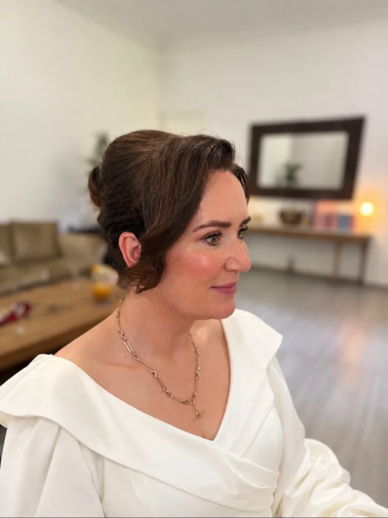 Soft updo with loose face-framing tendrils on a mature woman