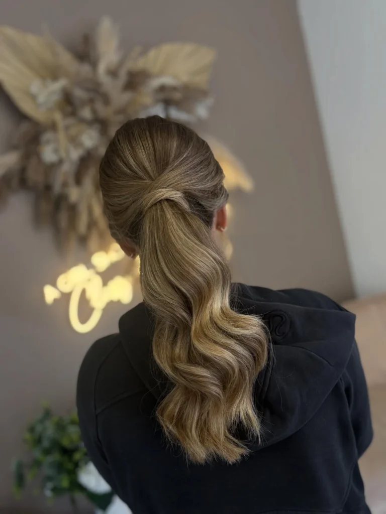 Twisted low ponytail with a wrapped base and wavy tail