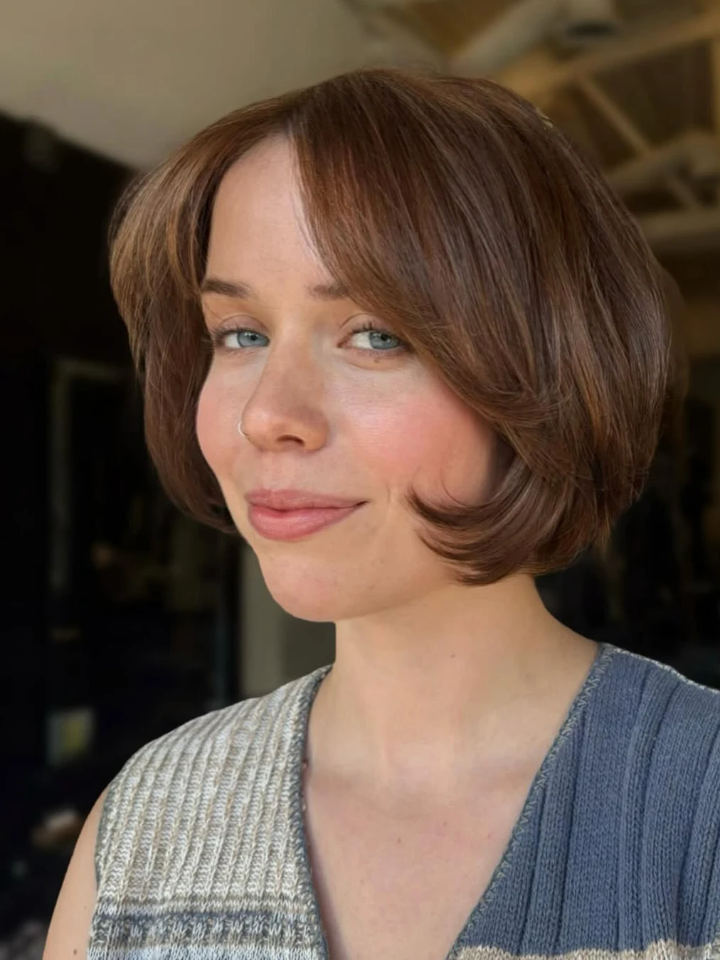 Auburn bob with curtain bangs parted in the middle